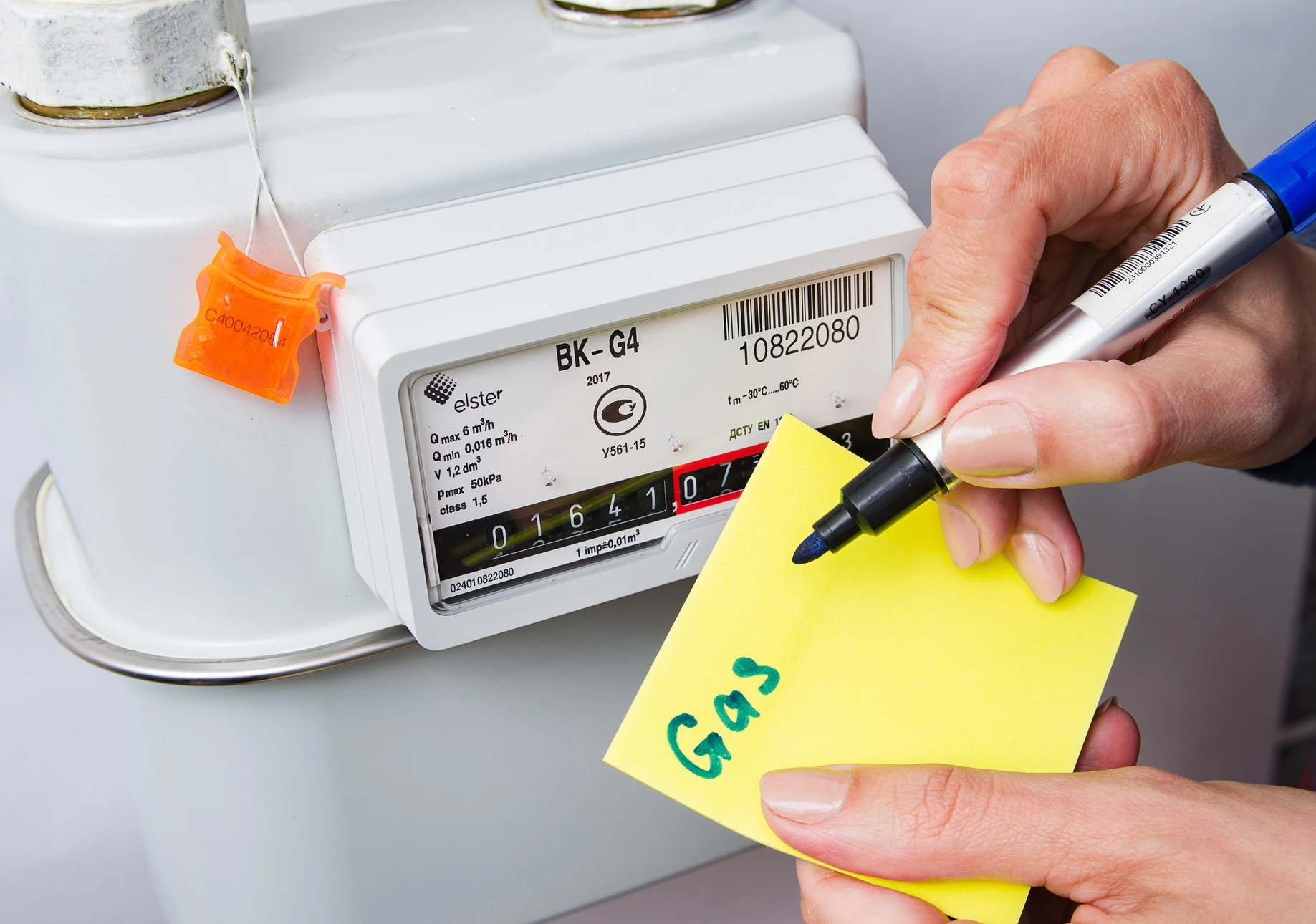 Scène intérieure montrant une personne effectuant la lecture d'un compteur de gaz domestique modèle BK-G4 Elster