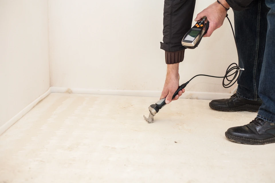 Intérieur résidentiel avec professionnel effectuant inspection technique au sol